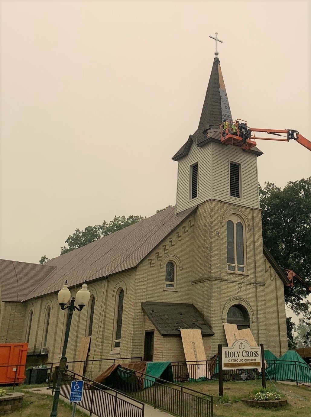 Fixins crew on a lift replacing the steeple roof at Holy Cross Catholic Church