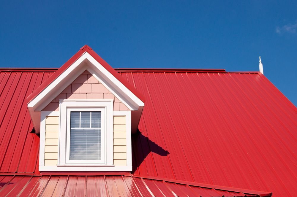 Red standing seam metal roof with a dormer window on a Colorado Springs home