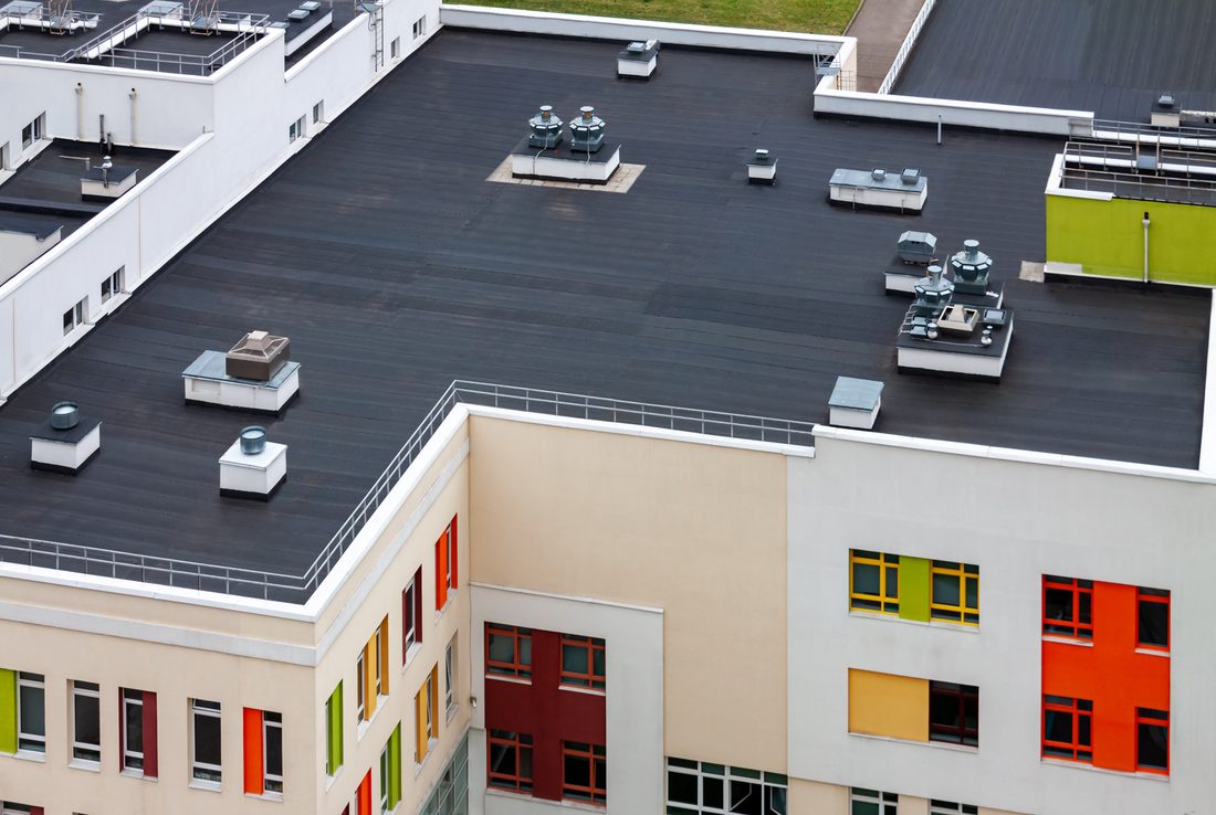 Roofing crew working on commercial flat roof system in Colorado Springs