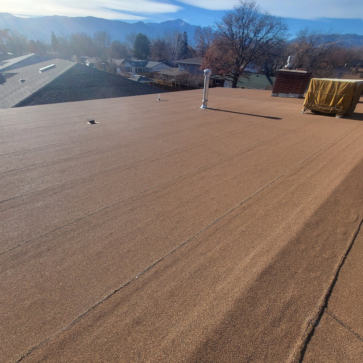 Old rolled roofing on a Colorado Springs home before TPO replacement