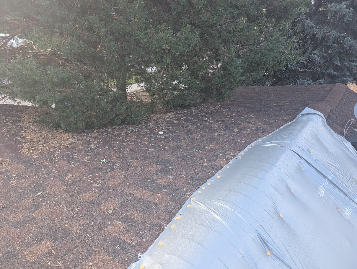 Emergency tarp secured over a storm-damaged roof to stop water intrusion in Colorado Springs