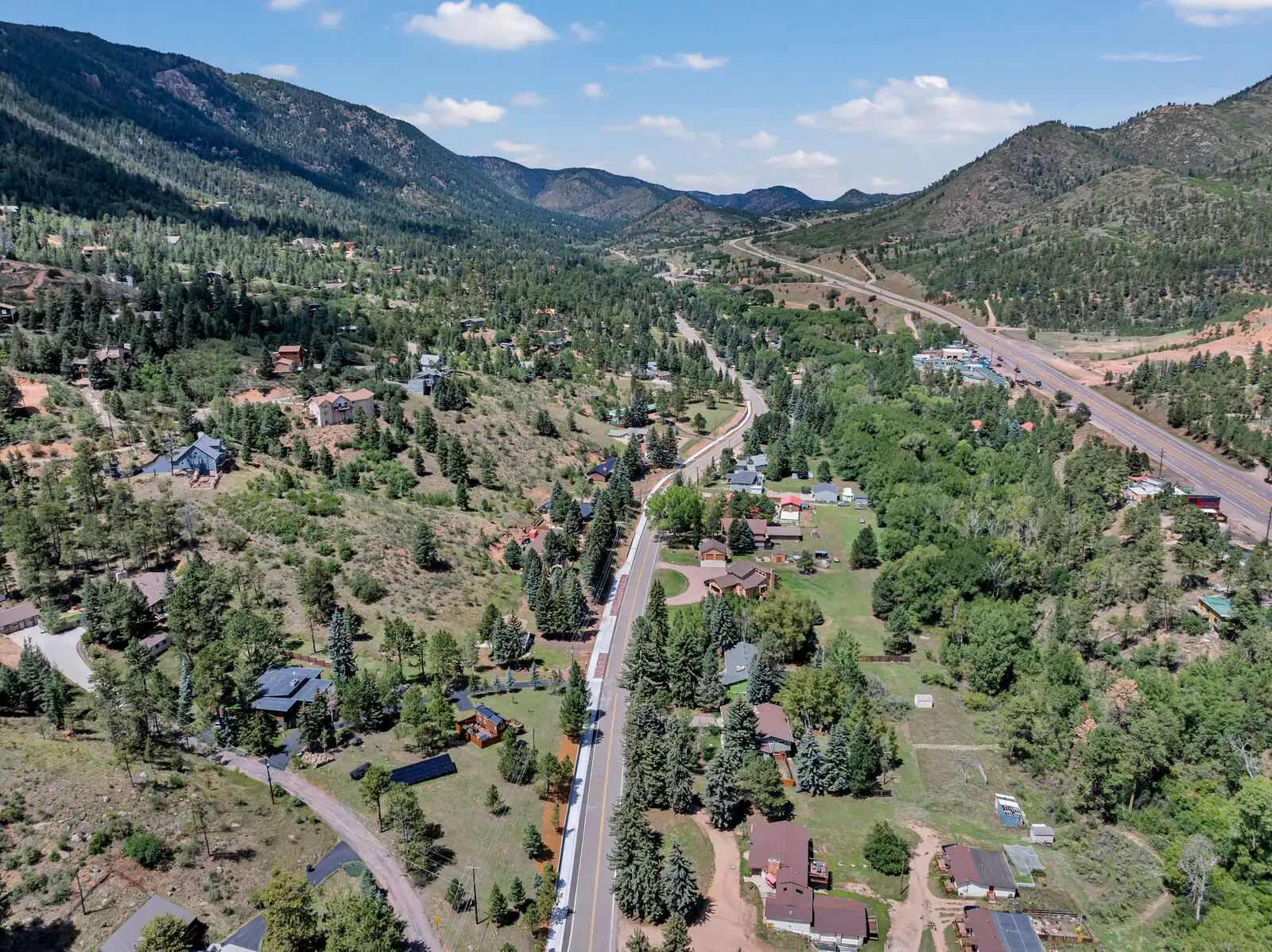 Aerial view of homes along the Ute Pass corridor in Cascade-Chipita Park, Colorado, with mountains rising behind the community