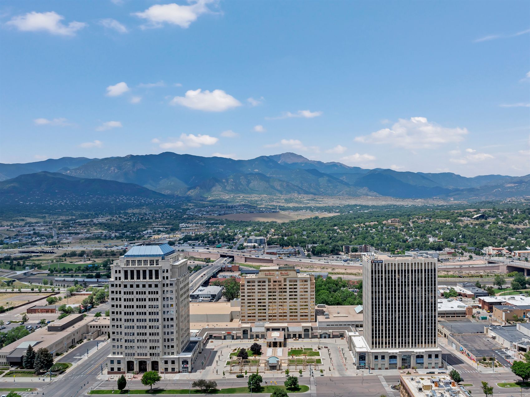 Aerial view of downtown Colorado Springs with Pikes Peak and the Front Range rising behind the city