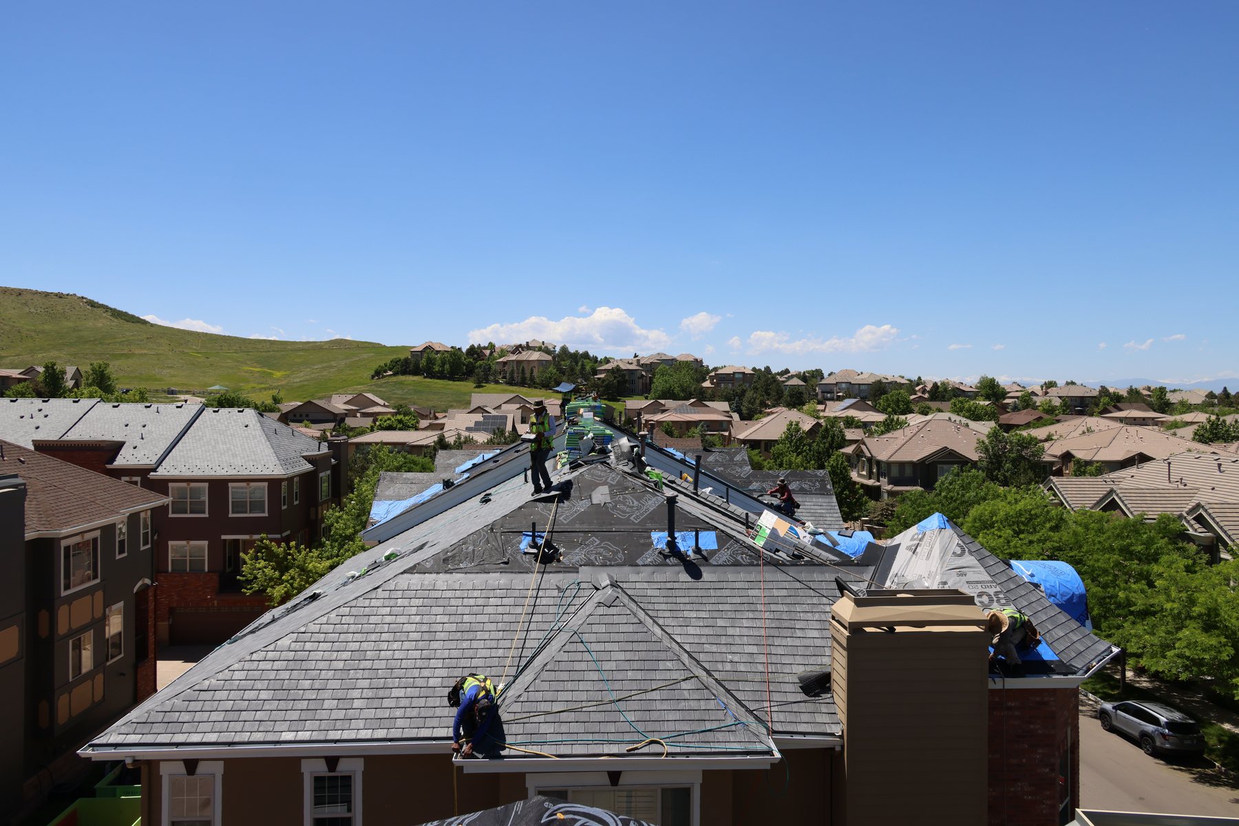 Fixins crew responding on a multi-plane roof over a Colorado Springs neighborhood