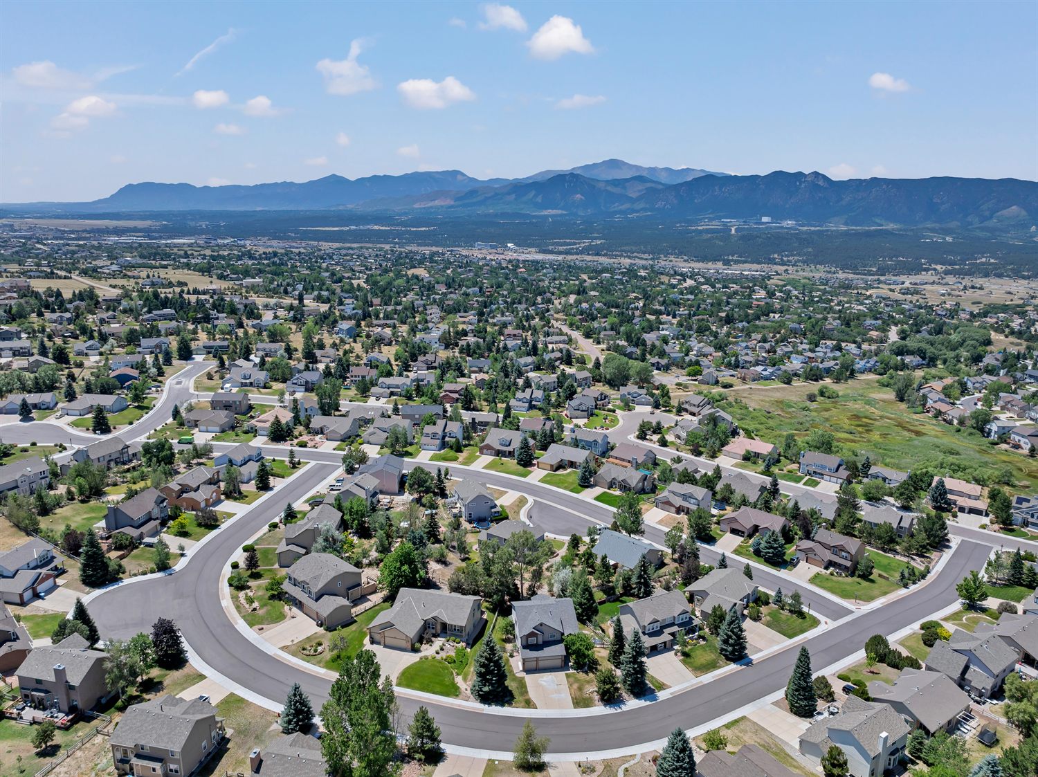 Aerial view of homes and streets in Gleneagle, Colorado Springs, with Pikes Peak and the Front Range behind