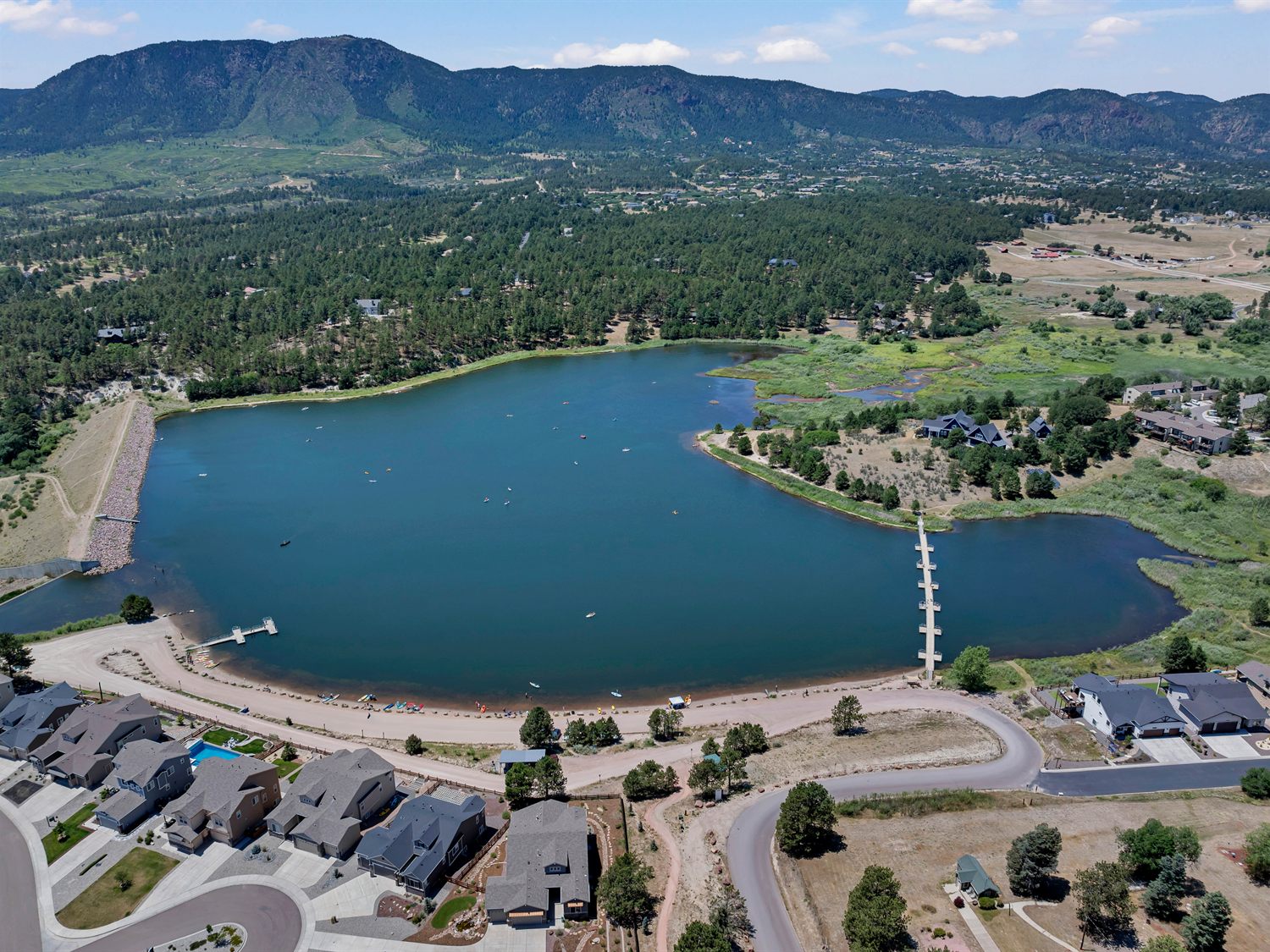 Aerial view of Monument Lake in Monument, Colorado, with homes along the shore and the Front Range behind