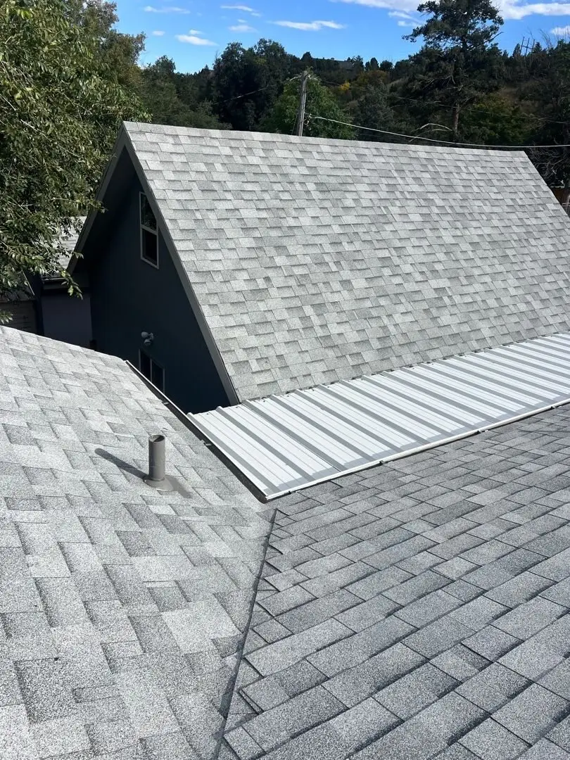 Manitou Springs re-roof by Fixins combining asphalt shingles with a standing seam metal section over the lower slope