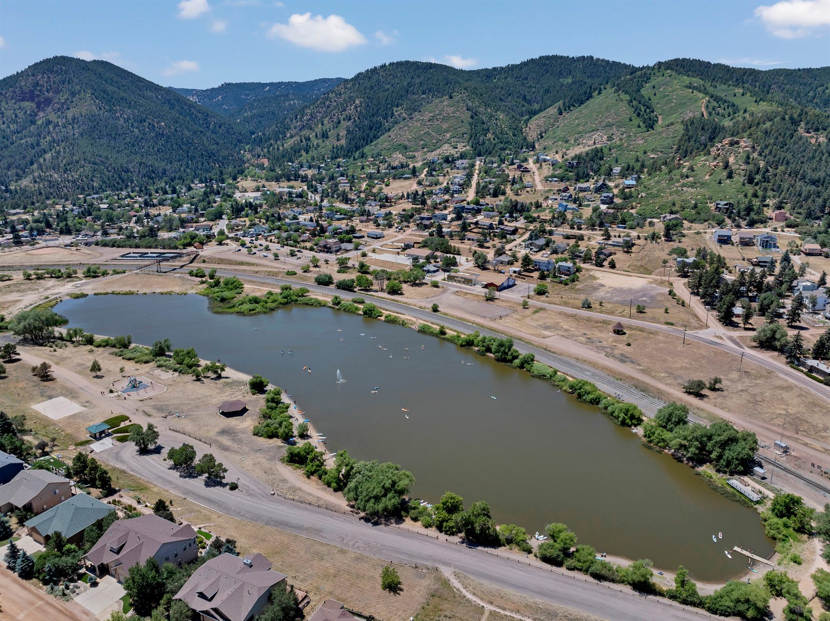 Aerial view of Palmer Lake, Colorado, with paddleboarders on the lake and the town below the foothills