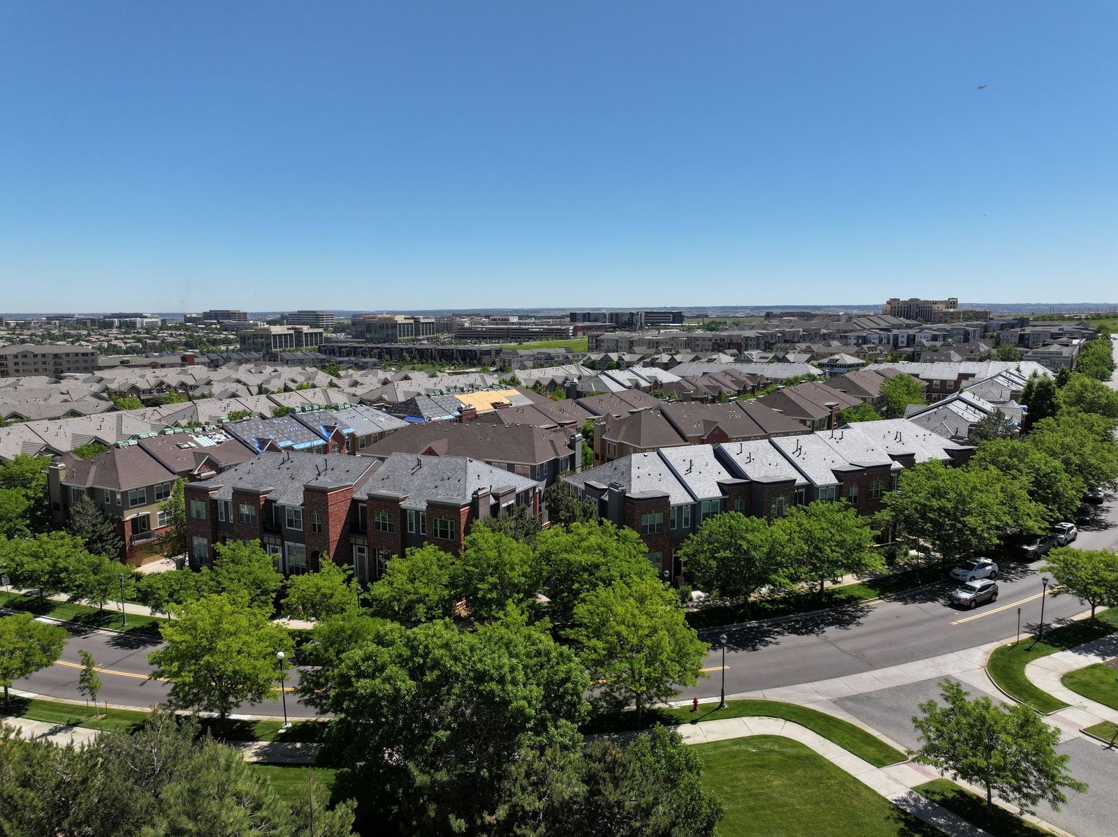 Aerial view of a Colorado Springs townhome community with roofs under repair after a storm
