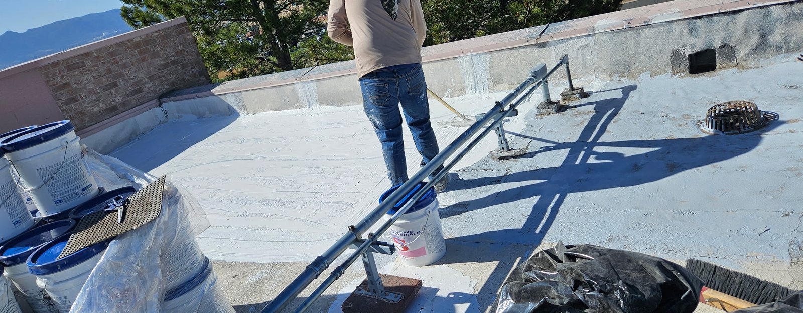 Roof coating project mid-application at the Briargate YMCA in Colorado Springs by Fixins Roofing and Restoration