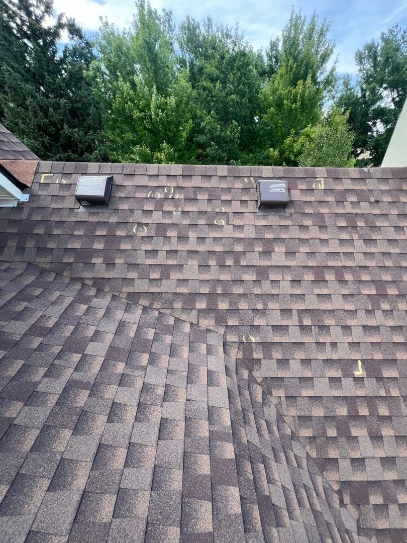 Fixins roof inspection with chalk-marked hail damage on a Broadmoor home in Colorado Springs