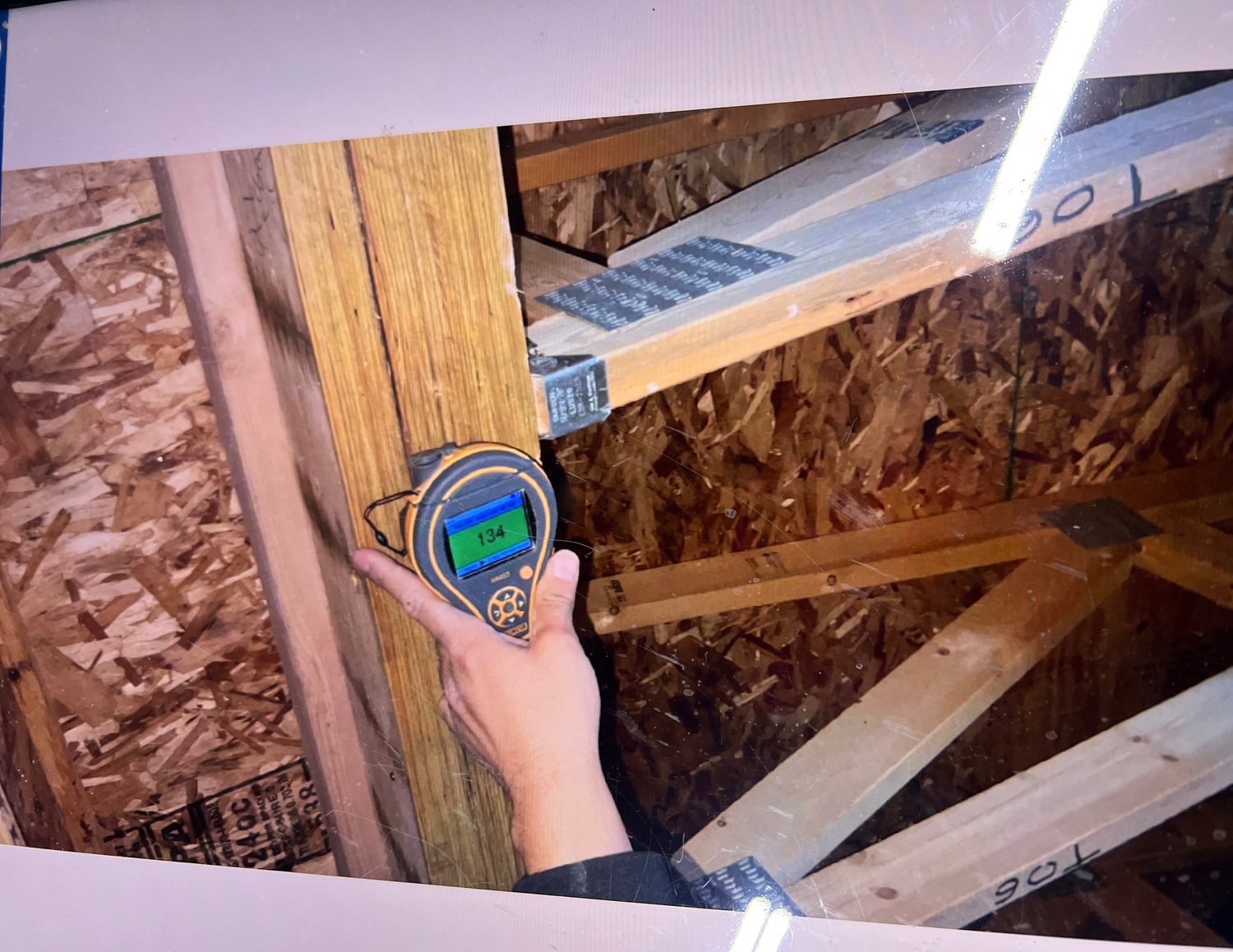Fixins technician taking a moisture meter reading on framing during a Colorado Springs water damage inspection