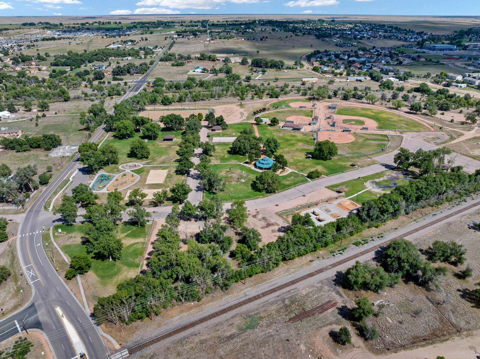 Aerial view of a Fountain, Colorado community park with ball fields beside the rail line